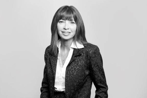 Presented on the website of a Hamilton, Ontario-based law firm is a monochrome portrait of a smiling woman. Her style reflects professionalism with her long bangs and patterned blazer accentuating her jovial demeanor.