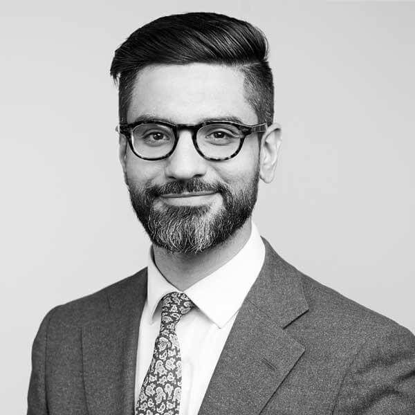 Our distinguished attorney, donning a professional suit complemented by a neat beard and glasses, represents our esteemed law firm based in Hamilton, Ontario. He is often photographed smiling for the camera because of his unwavering confidence in the legal services we provide.