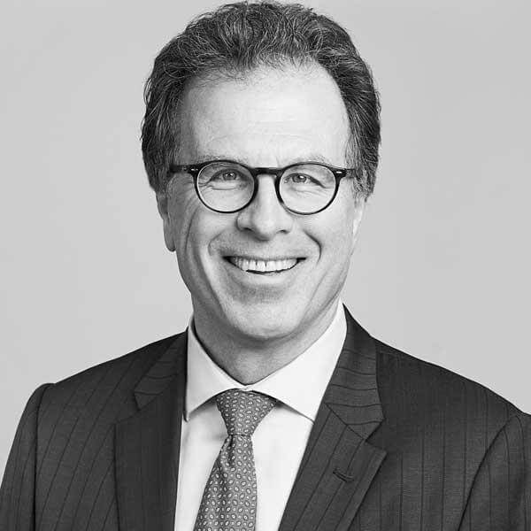 Professional monochrome portrait of a cheerful attorney, donned in a suit and glasses, from our esteemed law firm based in Hamilton, Ontario.