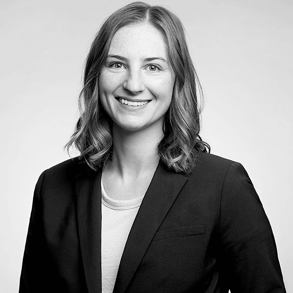 Professional female lawyer, impeccably attired, presenting a charming smile in an elegant black and white portrait at our esteemed Law Firm located in Hamilton, Ontario.