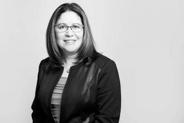 Professional female attorney featured in a black and white portrait for our esteemed Law Firm based in Hamilton, Ontario, exuding confidence and determination in her business attire.