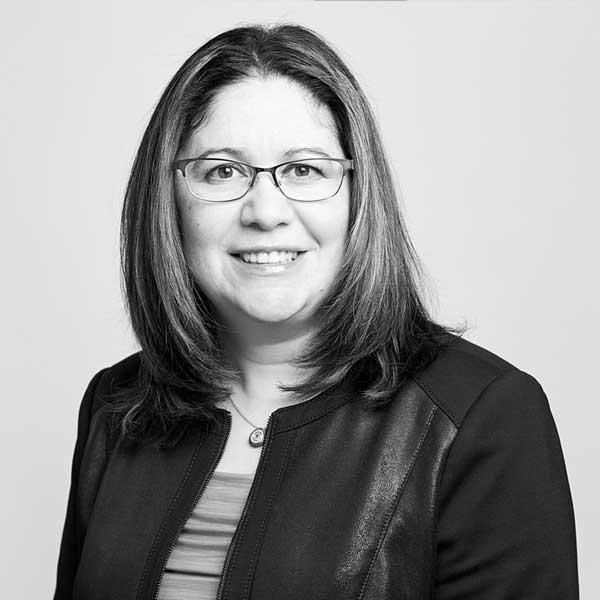 Professional monochrome portrait of a smiling female attorney with glasses, representing our prestigious law firm in Hamilton, Ontario.