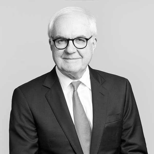 Senior partner portrayed against a gray background, displaying a congenial smile at our law firm located in Hamilton, Ontario.
