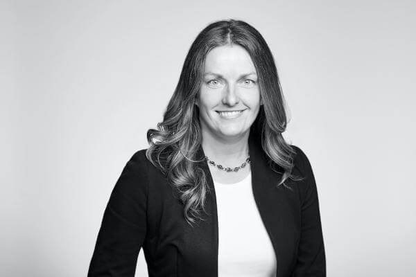 Professional black and white portrait of a cheerful woman, elegantly dressed in a business suit, proud to serve as part of our legal team at a renowned Law Firm based in Hamilton, Ontario.