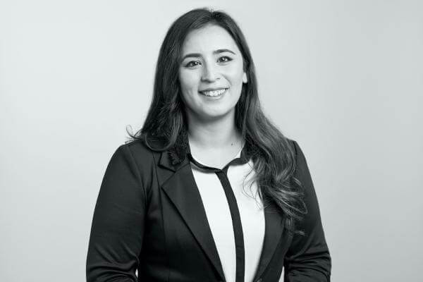 Professional woman, donned in a business suit, captured smiling at the camera in a tasteful black-and-white portrait for a distinguished law firm based in Hamilton, Ontario.