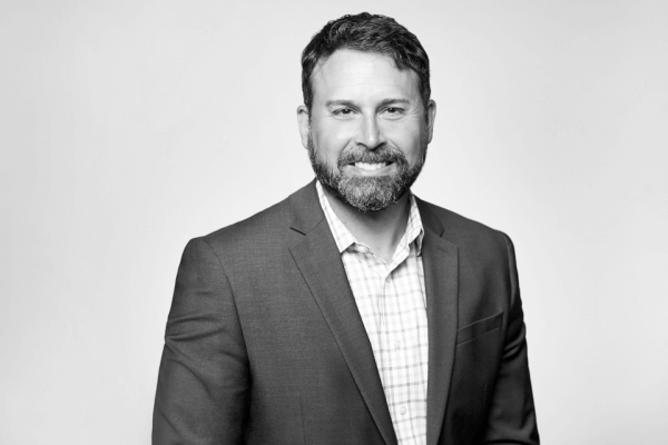A distinguished black and white photograph of a professional, bearded man affiliated with our law firm in Hamilton, Ontario, projecting a welcoming smile for the camera.