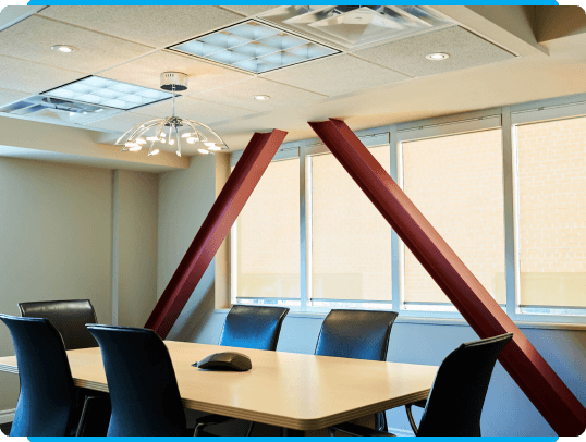 Our distinguished law firm in Hamilton, Ontario features a contemporary conference room. This space is thoughtfully designed with a sizable table and sleek black chairs for maximum comfort during consultations or meetings. The room's architectural details include exposed red beams, creating an atmosphere of professional elegance.