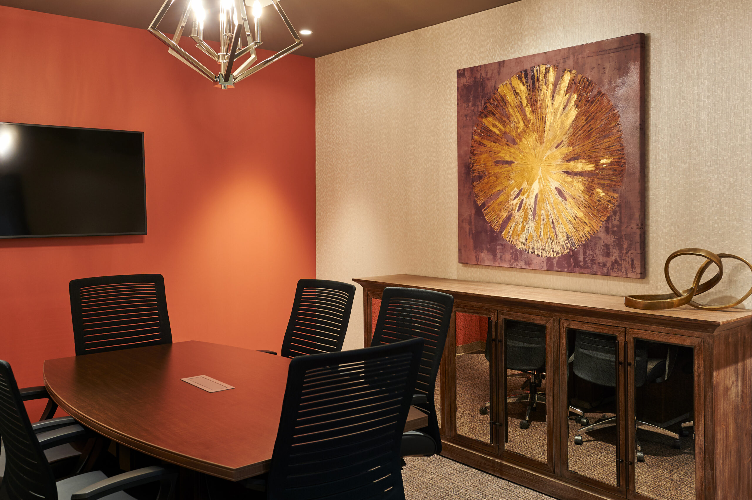 Our Hamilton, Ontario law firm boasts a contemporary conference room complete with a striking red accent wall, an intriguing abstract piece of art, and a state-of-the-art flat-screen TV.