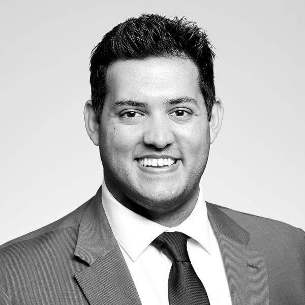 A sophisticated black and white professional portrait of a charismatic, suit-clad man is skillfully featured for our Law Firm based in Hamilton, Ontario.