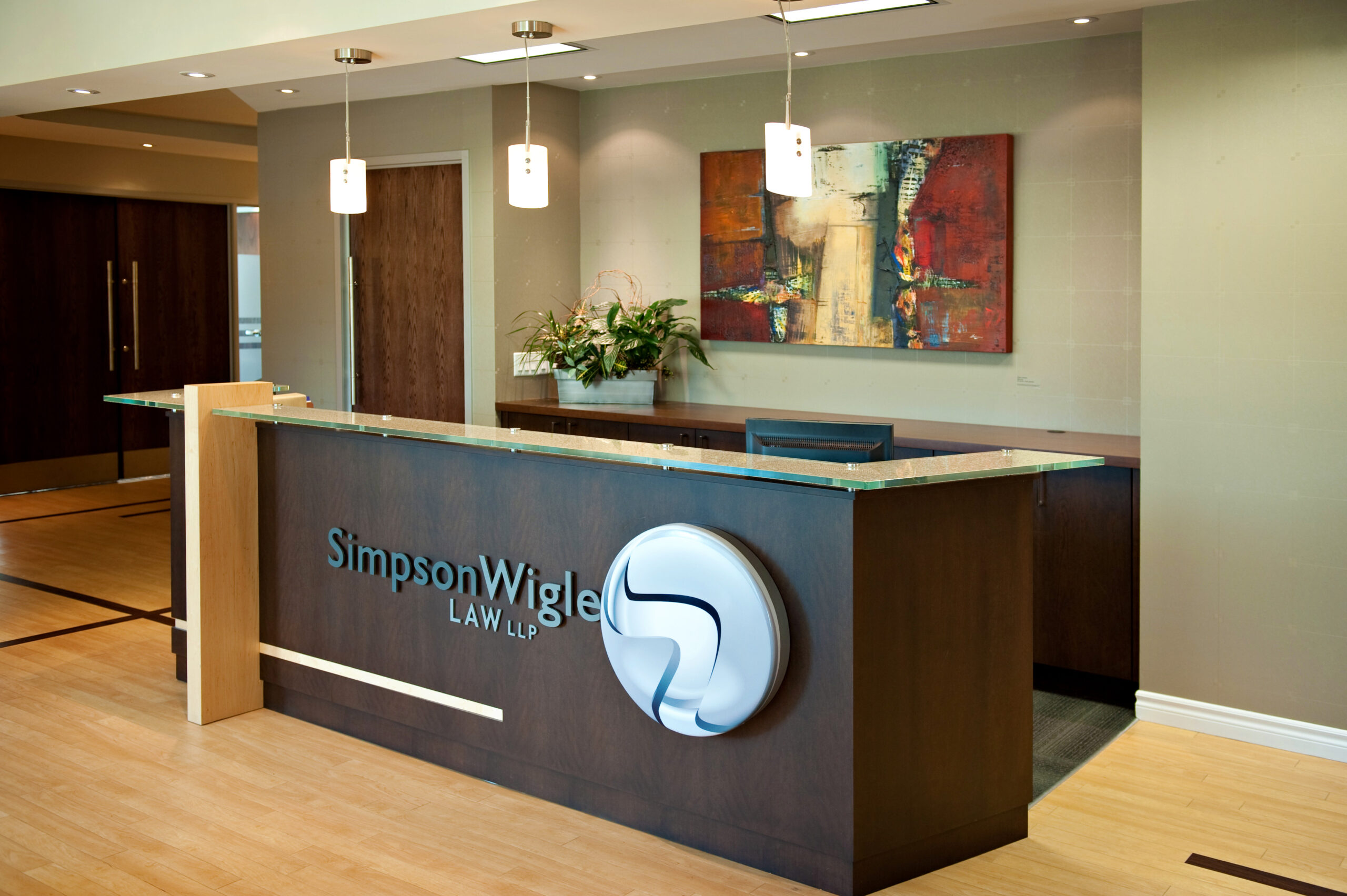 Our law firm, located in Hamilton, Ontario, boasts a modern reception area elegantly complemented by a contemporary art piece adorning the wall.