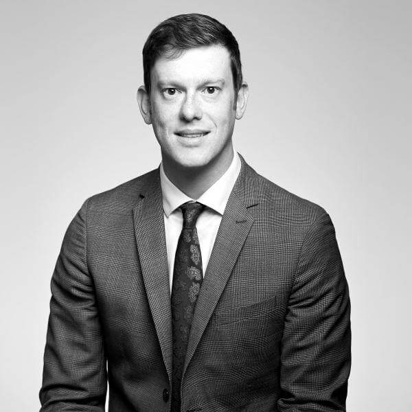 Monochrome portrait of a professional male attorney, dressed in suit and tie, from our esteemed law firm based in Hamilton, Ontario.