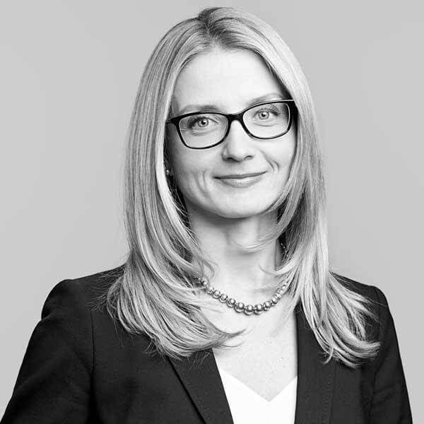 Proficient female attorney, wearing glasses, featured in a monochrome professional headshot at our law firm located in Hamilton, Ontario.